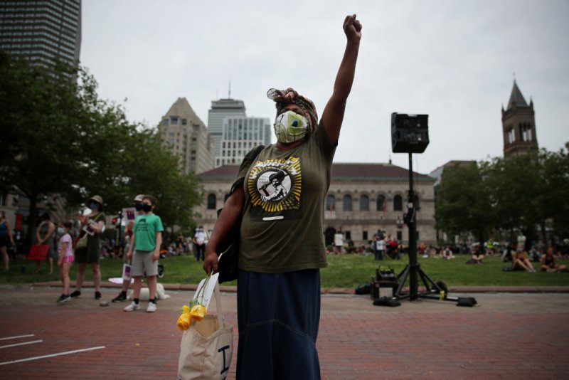 Janice Thomas, a mother of four, raises her fist during the March Like A Mother for Black Lives rally in Boston in June. Craig F. Walker / The Boston Globe—Getty Images